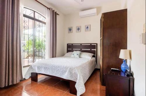 une chambre avec un lit et une grande fenêtre dans l'établissement Casa La Perla del Océano, à Herradura