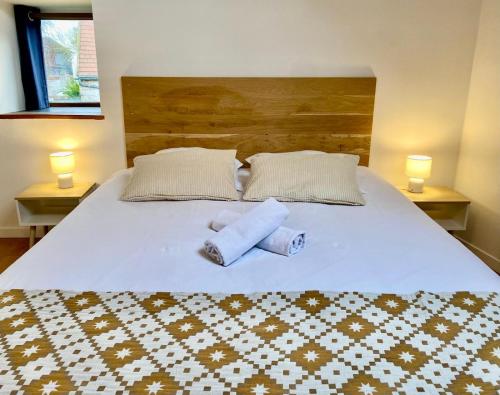 une chambre avec un lit avec deux serviettes dessus dans l'établissement Les maisons des Frangines, à Oinville-Saint-Liphard