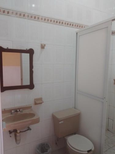 a bathroom with a toilet and a sink and a mirror at Hotel Posada Real in Chiapa de Corzo
