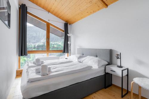 a bed in a room with a large window at homy Alpine Deluxe Chalet in St Anton im Montafon in Sankt Anton im Montafon