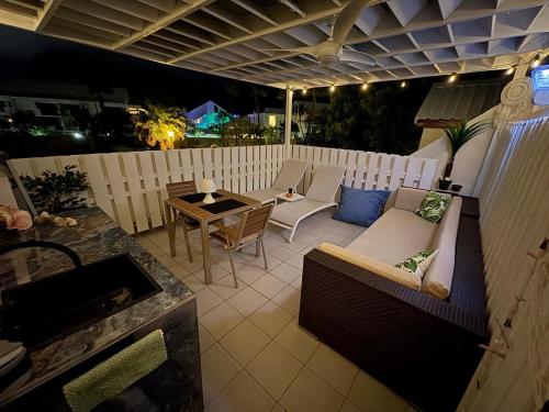 a patio with a couch and a table on a balcony at New sea view studio in Baie Nettle