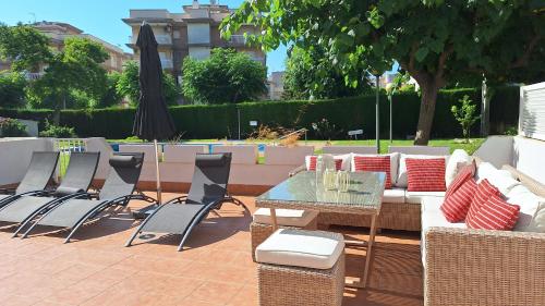 een terras met een tafel, stoelen en een parasol bij Cambrils Puerto in Cambrils