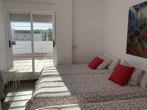 um quarto com uma cama com almofadas vermelhas em Casa Rural Nacimiento del Hueznar - Tomillo 17 em San Nicolás del Puerto