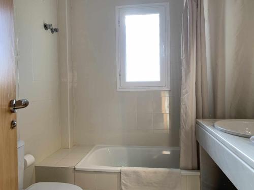 uma casa de banho com uma banheira, um WC e uma janela. em Casa Rural Nacimiento del Hueznar - Tomillo 17 em San Nicolás del Puerto