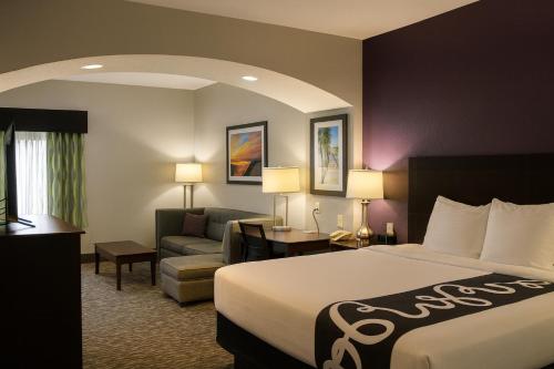 ポート・オレンジにあるLa Quinta by Wyndham Port Orange / Daytonaのベッドとソファのあるホテルの部屋
