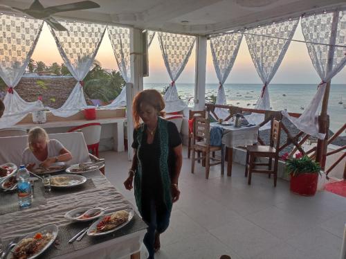 a little girl walking in front of a table with food at Nils Home in Nungwi