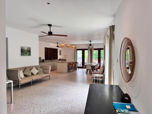 a large living room with a couch and a kitchen at Pear Tree House Barbados in Saint James