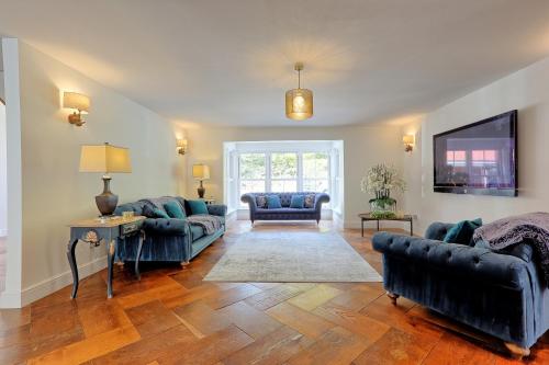 a living room with two couches and a tv at Mayrose House - 6BR 4BATH Luxe Spacious Retreat in Takeley