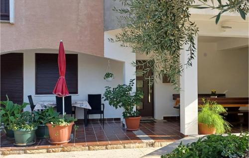 a patio with potted plants and a red umbrella at Gorgeous Apartment In Palit in Palit