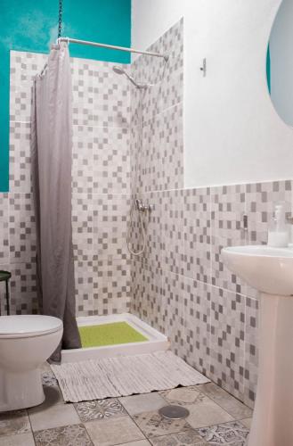 a bathroom with a shower and a toilet and a sink at Single Fin Surf Hostel in Arona