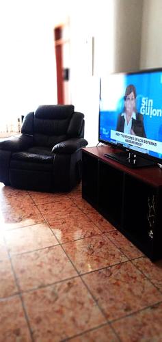 un salon avec un canapé et une télévision à écran plat dans l'établissement Departamento con Estacionamiento en Tacna, à Tacna