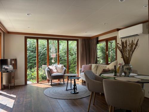 a living room with a couch and a table at Het Bosgeluk in Voorthuizen