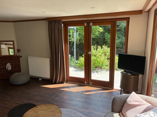 a living room with a sliding glass door at Het Bosgeluk in Voorthuizen