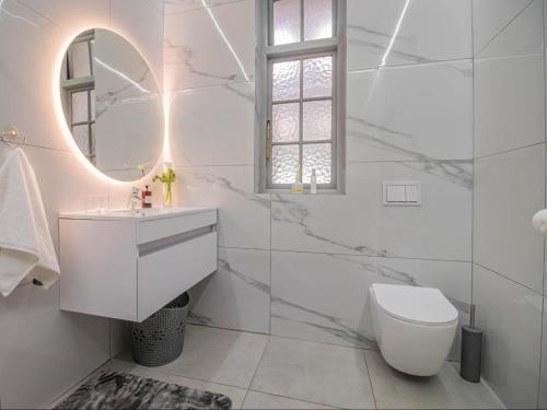 Un baño blanco con lavabo y espejo. en 15 On Le Roux, en Robertson