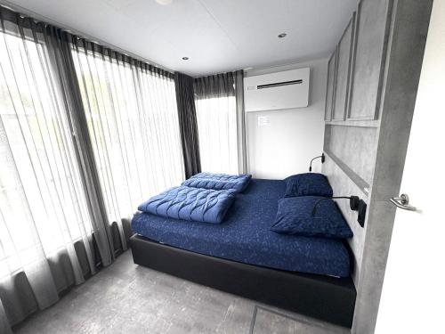 a bedroom with a bed with blue pillows on it at De Maasterp - Watervillage 14 in Ohé en Laak