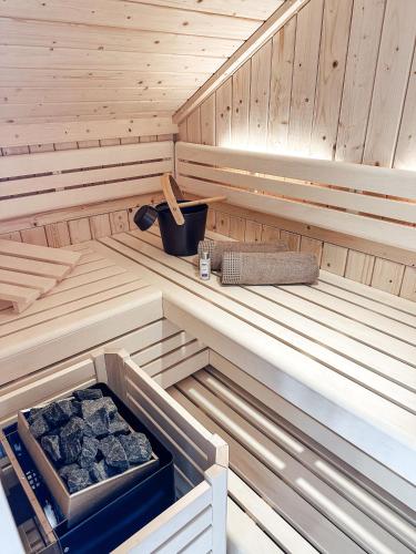 a inside of a sauna with a box of coal at Bachgeflüster-Suite in Bad Koetzting