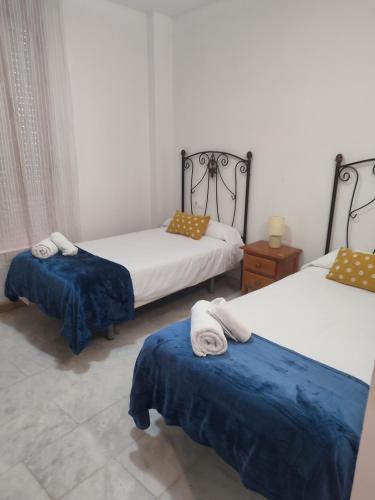 a room with two beds with towels on them at ALFONSo XII in Córdoba