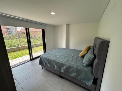 a bedroom with a bed and a large window at House 10 minutes from the airport, Rionegro in Rionegro
