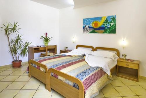 una camera con un letto e due piante di Albergo Villa Hibiscus a Ischia