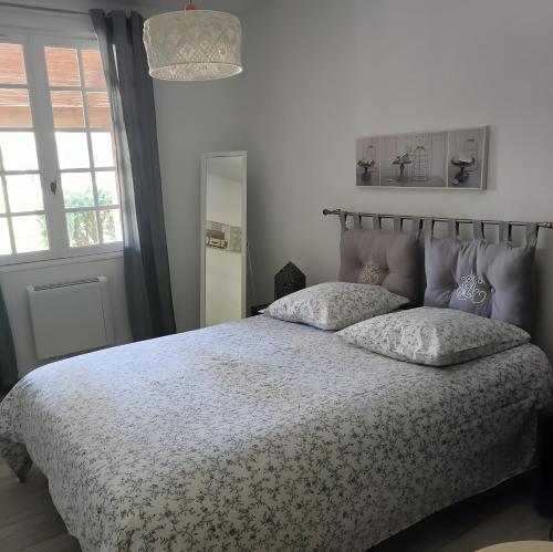 a bedroom with a bed with a white comforter at Les Berbéris - Gîte En Ardèche in Chandolas