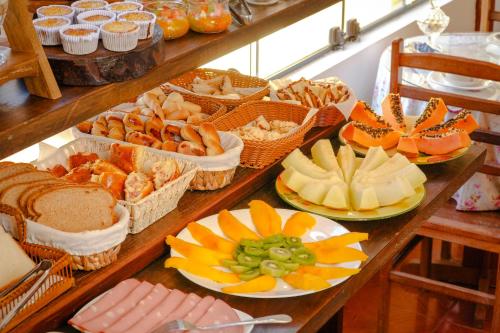 einen Tisch mit vielen Körben verschiedener Arten von Lebensmitteln in der Unterkunft VELINN Pousada Recanto da Natureza in Monte Verde