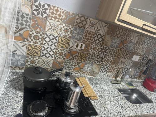 a kitchen counter with a stove and a tile wall at AP inteiro no Brás lado igrejas e comércio andar alto Estacionamento a combinar in São Paulo