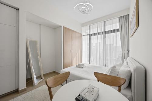 a room with a bed and two chairs and a table at Elite Escape - Getaway in Azizi Riviera 29 in Dubai