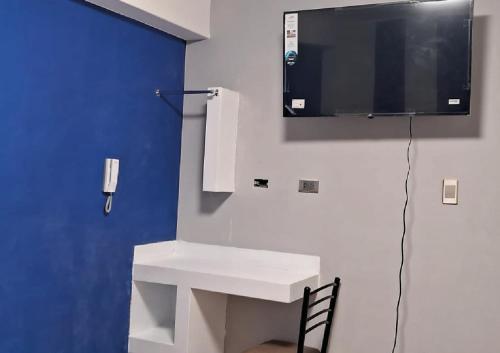 a bathroom with a sink and a tv on the wall at Hotel Huancayo - El Toro Wanka in San Antonio
