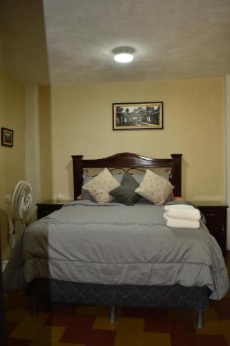 a bedroom with a large bed with pillows at El Rinconcito de la Antigua in Antigua Guatemala