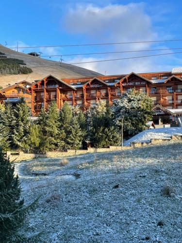 a large wooden lodge with trees in front of it at Appartement Alpe Huez 6 à 8 personnes centre station in LʼHuez