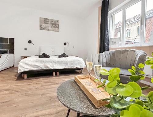 a bedroom with a bed and a table and a couch at Balnéo privée, Cinéma, Fibre & Patio in Tourcoing