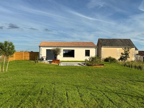 a house in the middle of a green field at Le Logis du Chêne - Piscine, proche Futuroscope in Vendeuvre-du-Poitou