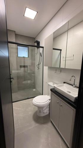 a bathroom with a shower and a toilet and a sink at Residencial Roberto Luiz Chiodi in Campos Novos