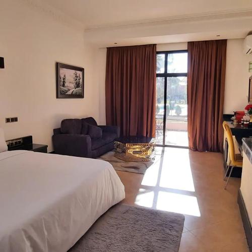 a hotel room with a large bed and a couch at Hôtel Jnane Ain Asserdoune in Oulad Yaïch
