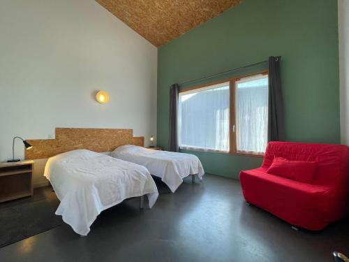 1 Schlafzimmer mit 2 Betten und einem roten Stuhl in der Unterkunft Gîte de la Gare 3 in Voulaines