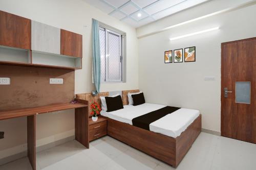 a bedroom with a bed and a wooden cabinet at Hotel O Radha Residency in Dahmi