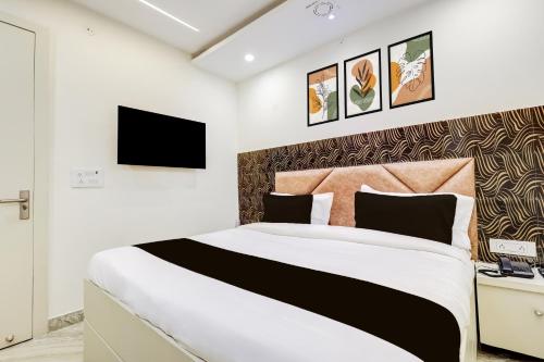 a bedroom with a large bed and a tv at Hotel O Roux residency in New Delhi