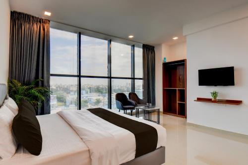 a bedroom with a large bed and a large window at Hotel O Lotus Inn in Chinchiwad