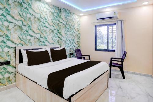 1 dormitorio con 1 cama grande y un mural en la pared en HOTEL O HAVELI INN, en Rāipur