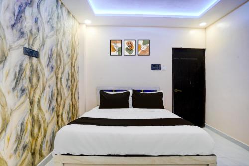 Un dormitorio con una cama y un cuadro en la pared. en HOTEL O HAVELI INN, en Rāipur