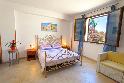 Un dormitorio con una cama y una silla y una ventana. en Agriturismo Masseria Terra D'Otranto, en Otranto
