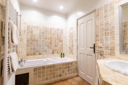a bathroom with a tub and a sink at La Prévôté - Luxury Chambres d'hôtes & Gastronomic Restaurant in L'Isle-sur-la-Sorgue