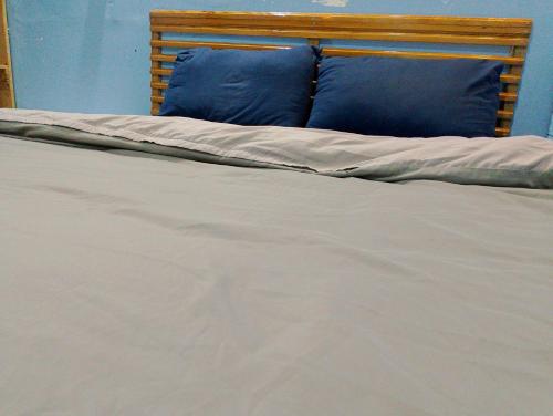 un letto con cuscini blu di Vuong Tran Dalat Inn Retreat a Da Lat