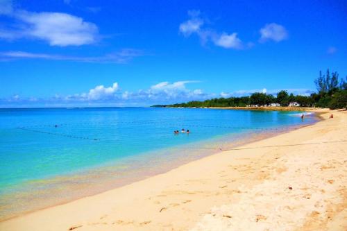 a beach with people swimming in the water at Villa Kaz a Ramon in Port-Louis