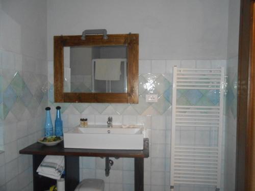 uma casa de banho com um lavatório branco e um espelho. em Casa della Valle em Trisobbio