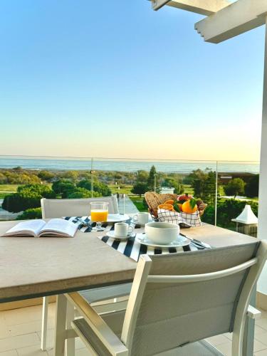 a dining room table with a view of the ocean at Pérola do Oceano in Manta Rota