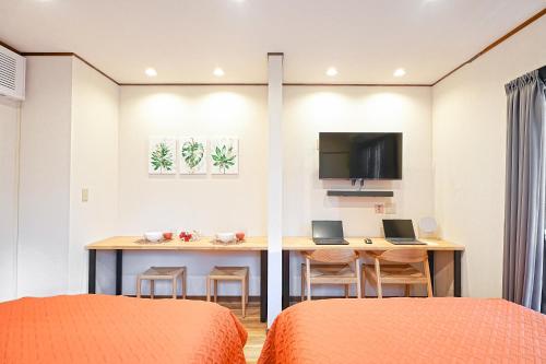 a bedroom with two beds and a desk with two laptops at Unite Stay Gyotoku in Tokyo