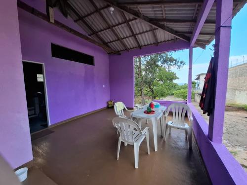 a patio with a table and chairs on a purple wall at Casa Brisa do Tapajós in Santarém