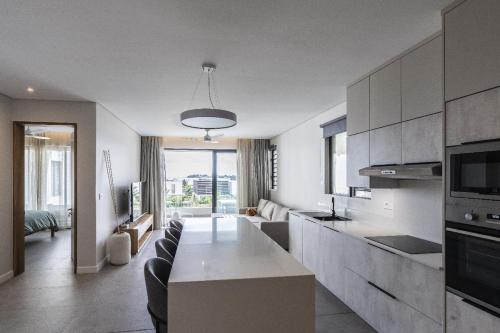 a kitchen and living room with a table and a couch at Asmara Mauritius Oceanfront Retreat in Petite Case Noyale