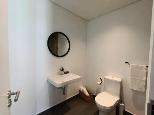 biała łazienka z toaletą i umywalką w obiekcie Kkape Sands - Peak Views From Sea Point Pad w Kapsztadzie